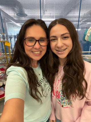 Two women smiling together inside the boutique